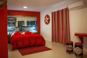 a bedroom with a red bed and red curtains at Pousada Serra Azul in Urubici