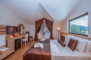a bedroom with a large bed with a desk and a window at S3 Seahorse Beach Club in Oludeniz