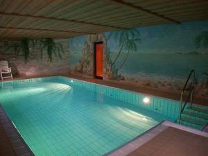 a large swimming pool in a room with a painting at Hotel Mühlenberg in Bad Sachsa