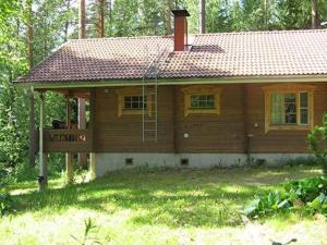 a small wooden house with a porch in the yard at Holiday Home Mustikka by Interhome in Röylä
