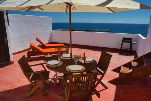 a patio with a table and chairs and an umbrella at Casa Miramar in Gran Tarajal