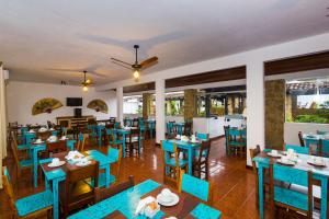 ein Restaurant mit blauen Stühlen und Tischen und Fenstern in der Unterkunft Pousada Aconchego in Paraty