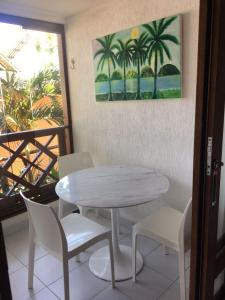 tavolo e sedie in una stanza con un quadro di Apartamento 01 Enseada Praia do Forte a Praia do Forte