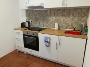 a kitchen with a sink and a stove top oven at Casa Valientes B - Free private parking, patio, WiFi & AC in Jerez de la Frontera