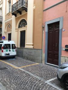 uma carrinha branca estacionada em frente a um edifício em B&B Juighissa Leonora em Oristano