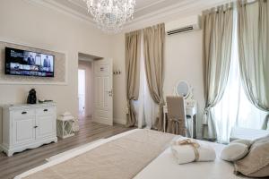 una camera bianca con un grande letto e un lampadario a braccio di Charme & Chic Luxury a Roma