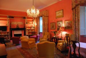 a living room with orange walls and a chandelier at Villa Carola in San Giuliano Terme