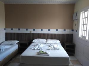 two beds in a room with two windows at Ville House Hotel Canoas in Canoas