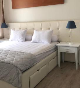 a bed with a white headboard and a side table at A beautiful and Spacious Rumah Manado 2 Bedrooms with Bathrooms Villa Marion Tomohon in Tomohon