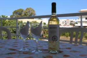 a bottle of wine sitting on a table with two glasses at Vila Marachique V Alvor in Alvor