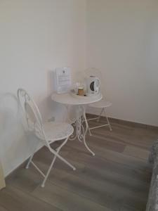 a table with two chairs and a table with a cup at Alloggio I Grifoni in Ferrara