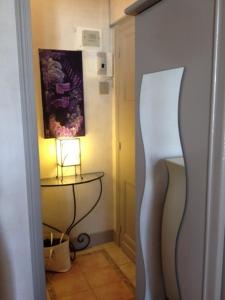 einen Flur mit einem Tisch und einer Lampe in einem Zimmer in der Unterkunft Studio Cannes Croisette in Cannes