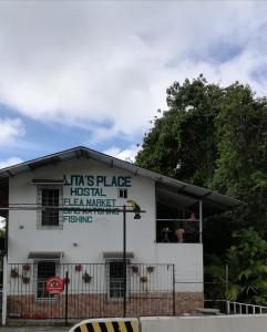 a white building with a sign on the side of it at Lita's Place in Cordillera Arriba