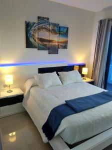 una camera da letto con un letto con tre dipinti sul muro di Ocean Front Apartment (WiFi) a Tetir