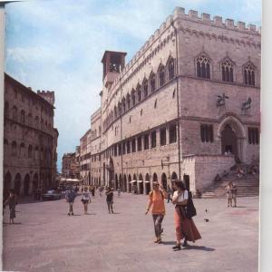 um grupo de pessoas andando em torno de um grande edifício em Freetime em Perugia