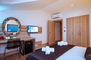 a bedroom with a bed and a desk and a mirror at S3 Seahorse Beach Club in Oludeniz