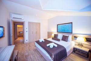 a bedroom with a large bed with two white towels at S3 Seahorse Beach Club in Oludeniz