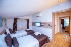 a hotel room with two beds and a tv at S3 Seahorse Beach Club in Oludeniz