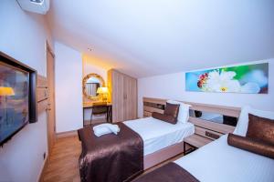 a hotel room with two beds and a tv at S3 Seahorse Beach Club in Oludeniz