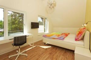 a bedroom with a bed and a desk and a chair at Kapitaensweg 32 in Ostseebad Karlshagen