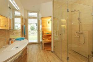 a bathroom with a glass shower and a sink at Kapitaensweg 32 in Ostseebad Karlshagen