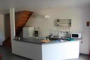 une petite cuisine avec un comptoir et un micro-ondes dans l'établissement Chez Marie et christian, à La Boussac