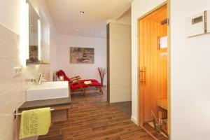 a bathroom with a white sink and a red chair at Kapitaensweg 18 in Ostseebad Karlshagen
