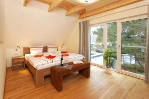 a bedroom with a large bed and a large window at Kapitaensweg 18 in Ostseebad Karlshagen +11 photos