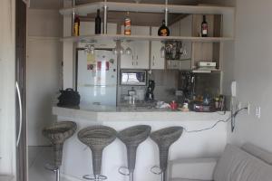 una cucina con due sgabelli da bar di fronte a un bancone di Estrela do Mar a Florianópolis
