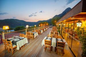 a restaurant with tables and chairs on a deck at S3 Seahorse Beach Club in Oludeniz