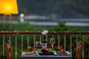 a table with two glasses of wine and food at S3 Seahorse Beach Club in Oludeniz