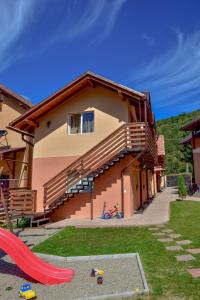 a house with a playground with a slide in the yard at Kovács Guesthouse in Praid