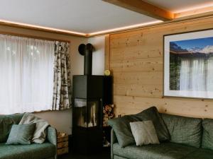 a living room with a couch and a fireplace at Apartment Bärggeist by Interhome in Adelboden