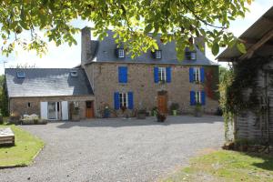 La BoussacにあるChez Marie et christianの青い窓と私道のある大きな石造りの家