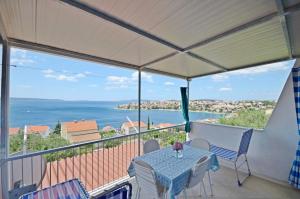 a table on a balcony with a view of the ocean at Apartments Doris in Trogir