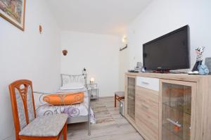 a living room with a flat screen tv on a wooden cabinet at Apartments Doris in Trogir