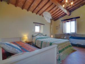 a bedroom with two beds and two windows at Holiday Home Casalini by Interhome in Montorgiali
