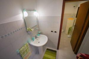 a small bathroom with a sink and a mirror at Idillio Mediterraneo in Magomadas
