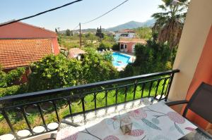 a balcony with a table and a view of a pool at Elena Apartments Corfu in Acharavi