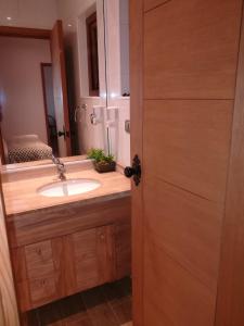 y baño con lavabo y espejo. en Torres Del Sur Cabañas & Hostal, en Villarrica