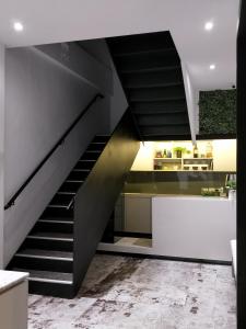 羅東鎮的住宿－小小邸 Small Hotel，楼梯通往带柜台的厨房