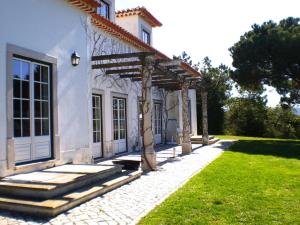 オビドスにあるCasa da Várzea, perto do Castelo de Óbidosの庭に隣接するパーゴラ付白い家