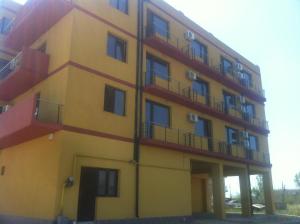 a yellow building with balconies on the side of it at Orient Mamaia Nord in Mamaia Sat/Năvodari