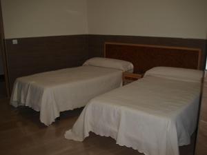 two beds with white sheets in a room at Domus Viatoris in Sahagún