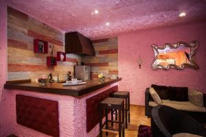 a bar in a room with a pink wall at luxury suite in Ciempozuelos