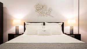 a bedroom with a large white bed with two lamps at Bugalha My Loft Douro 4 in Peso da Régua