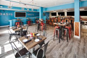 a restaurant with tables and chairs and a bar at Red Lion Hotel Orlando Lake Buena Vista South- Near Disney in Kissimmee