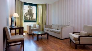 Apartamentos TH Las Rozas في لاس روزاس دي مدريد: غرفة معيشة مع أريكة وكراسي وطاولة