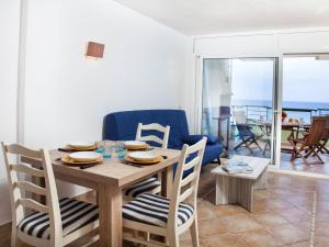 a dining room with a table and chairs with a view of the ocean at Apartment Vermell-8 by Interhome in Platja  d'Aro