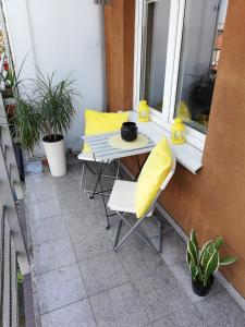 ポズナンにあるQuiet-Apartments Długoszaのテーブルと椅子、バルコニー(黄色い枕付)